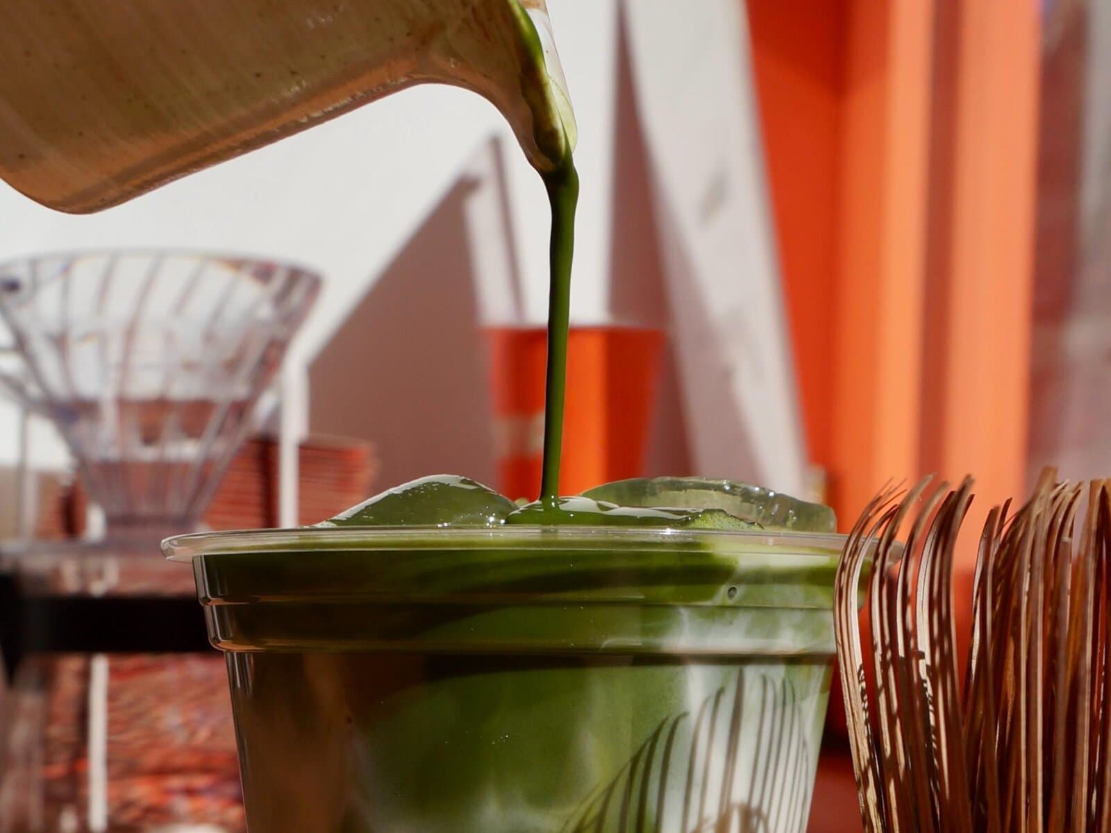 Ceremonial-grade matcha being poured into a CONA cup